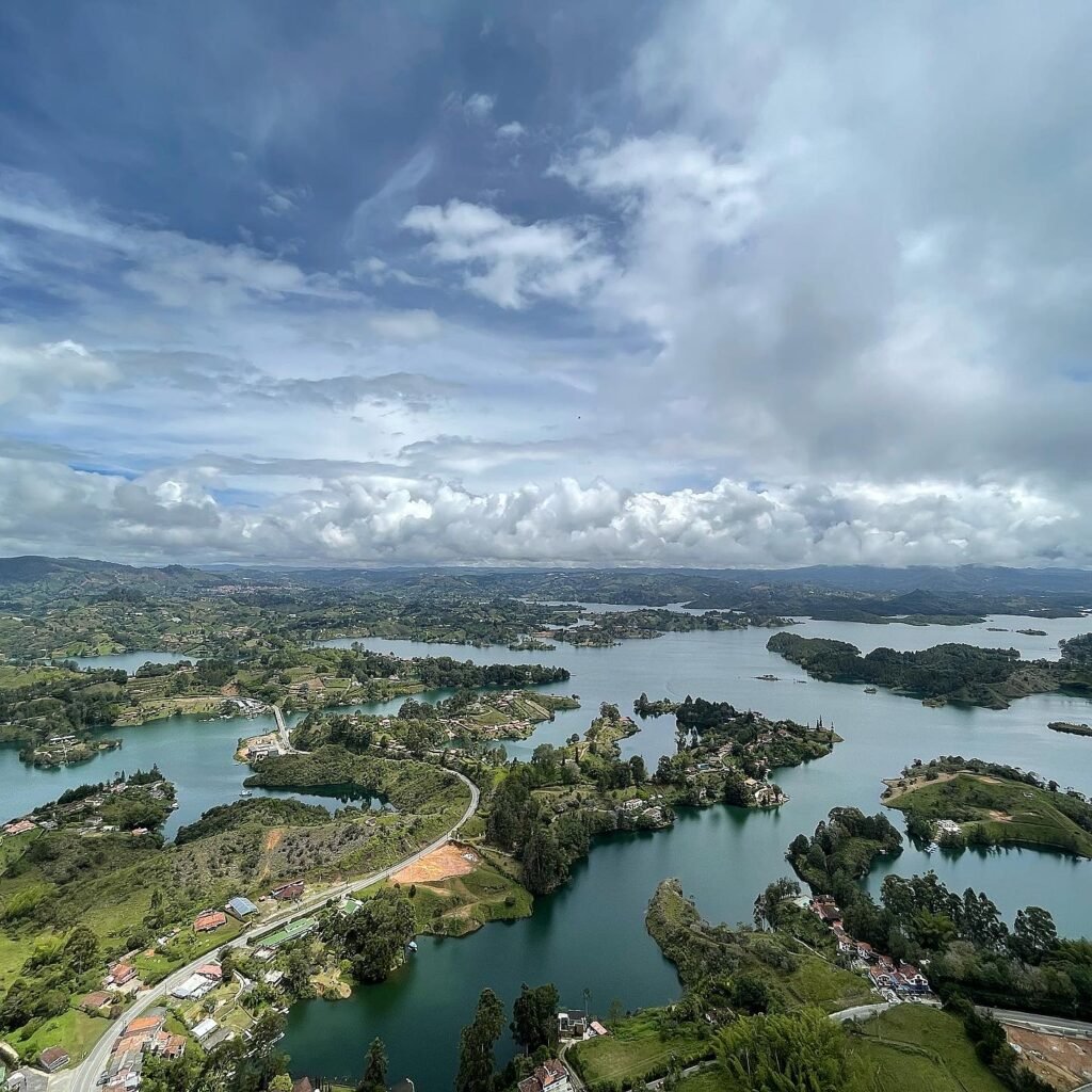 Vista aérea de Guatapé, Colombia, con islas verdes y lagos azules bajo un cielo nublado, ideal para consejos de fotografía de viajes.